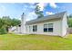 Wide shot of a backyard with a basketball goal, white siding, and a stone chimney at 2221 Baker Carter Dr, Loganville, GA 30052