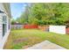 A large backyard with a combination wood and red painted fence and white utility building at 2221 Baker Carter Dr, Loganville, GA 30052