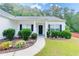 Inviting front entrance with manicured bushes and flowers along the walkway and a covered porch at 2221 Baker Carter Dr, Loganville, GA 30052