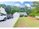 Traditional single-story home with a well-maintained lawn, attached garage, and long driveway with parked cars at 2221 Baker Carter Dr, Loganville, GA 30052