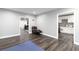 Open living space with dark wood floors, gray walls, a cozy recliner, and an open doorway to the kitchen at 2221 Baker Carter Dr, Loganville, GA 30052