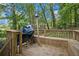 Relaxing back deck, surrounded by trees, features seating, a birdhouse, and a grill for outdoor gatherings at 2950 Springfield Sw Ct, College Park, GA 30349