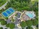 Aerial view showcases community amenities: tennis courts, a pool, parking, and clubhouse, all surrounded by lush trees at 337 Spotted Ridge Cir, Woodstock, GA 30188