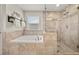 Beautiful tiled shower with a glass door and a soaking tub with a window at 337 Spotted Ridge Cir, Woodstock, GA 30188