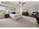 Spacious main bedroom featuring tray ceilings, a ceiling fan, and large windows for natural light at 337 Spotted Ridge Cir, Woodstock, GA 30188