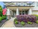 Charming front porch with brick columns and lush landscaping, featuring a welcoming American flag at 337 Spotted Ridge Cir, Woodstock, GA 30188