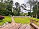 Expansive backyard view featuring a tiered yard, pool area, mature trees, and a wooden deck at 792 Oneta Dr, Norcross, GA 30093