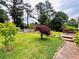 Spacious backyard featuring a healthy lawn and mature landscaping, complemented by a wooden deck at 792 Oneta Dr, Norcross, GA 30093