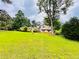 View of the split-level home surrounded by a spacious green lawn and mature trees at 792 Oneta Dr, Norcross, GA 30093