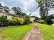 Inviting home exterior featuring a well-manicured lawn, mature shrubs, and a sidewalk leading to the entrance at 792 Oneta Dr, Norcross, GA 30093