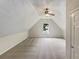 Carpeted attic with vaulted ceiling, ceiling fan and natural light from a window at 834 Winding Grove Ln, Loganville, GA 30052