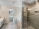 Bright bathroom featuring a tiled shower, soaking tub, and vanity with gray tiled floors at 834 Winding Grove Ln, Loganville, GA 30052
