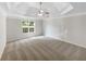 Bright main bedroom features a decorative ceiling, fan, carpet flooring and a large window at 834 Winding Grove Ln, Loganville, GA 30052