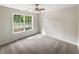Carpeted bedroom with ceiling fan and large window offering natural light at 834 Winding Grove Ln, Loganville, GA 30052