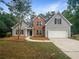 Charming two-story home with stone accents, manicured lawn, a two car garage and mature trees at 834 Winding Grove Ln, Loganville, GA 30052
