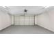 Clean, empty two-car garage featuring white walls, epoxy flooring and an automatic door opener at 834 Winding Grove Ln, Loganville, GA 30052