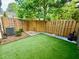 Private backyard featuring artificial turf, a wooden fence, decorative elements, and a compact AC unit at 2167 Del Lago Cir # 11, Kennesaw, GA 30152
