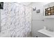 Modern bathroom with a marble-patterned shower curtain, gray vanity, and stylish decor creating a relaxing space at 246 Aurora Nw Ave, Atlanta, GA 30314