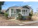 Angle view of a quaint green bungalow featuring a white-railed front porch and tidy landscaping at 246 Aurora Nw Ave, Atlanta, GA 30314