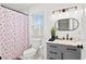 Bright bathroom featuring gray cabinets, elegant lighting fixtures, and a floral shower curtain at 251 Aurora Nw Ave, Atlanta, GA 30314