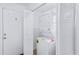 A bright laundry room featuring a stackable washer and dryer and a white door at 251 Aurora Nw Ave, Atlanta, GA 30314