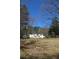 Expansive backyard with mature trees, fire pit, storage shed and recreational equipment at 2184 E Cherokee Dr, Woodstock, GA 30188