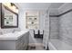 Stylish bathroom with gray vanity, tiled walls, and shower-tub combination at 2184 E Cherokee Dr, Woodstock, GA 30188