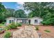 Charming single-story home featuring a stone walkway, lush landscaping, and inviting front porch at 2184 E Cherokee Dr, Woodstock, GA 30188
