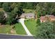 Aerial view of a beautiful home with a long driveway, manicured lawn, and surrounded by lush trees at 2702 Moorings Pkwy, Snellville, GA 30039