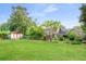 Expansive backyard with lush green lawn, mature trees, garden shed, and landscaping at 2702 Moorings Pkwy, Snellville, GA 30039