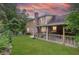 Home boasts a large backyard featuring a covered patio and mature trees under a sunset at 2702 Moorings Pkwy, Snellville, GA 30039
