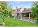 Spacious backyard featuring a covered patio, green lawn, and mature trees, perfect for outdoor living at 2702 Moorings Pkwy, Snellville, GA 30039