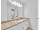 Bathroom with large mirror over granite countertops, white cabinets, and tiled flooring at 2702 Moorings Pkwy, Snellville, GA 30039