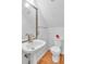 Well-lit bathroom features a pedestal sink, toilet, and hardwood floors at 2702 Moorings Pkwy, Snellville, GA 30039