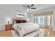Well-lit bedroom with a ceiling fan, warm hardwood floors, large window, and comfortable furnishings at 2702 Moorings Pkwy, Snellville, GA 30039