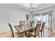 Formal dining room featuring modern furnishings, an elegant chandelier, and large window with curtains at 2702 Moorings Pkwy, Snellville, GA 30039