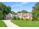 Charming brick home with a well-manicured lawn, dormer windows and a long driveway leading to a two-car garage at 2702 Moorings Pkwy, Snellville, GA 30039