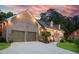 Charming single-Gathering home featuring a brick facade, gabled roof, and a two-car garage, all illuminated at dusk at 2702 Moorings Pkwy, Snellville, GA 30039