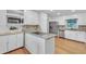 Bright kitchen features white cabinets, stainless steel appliances, granite countertops, and a functional island cooktop at 2702 Moorings Pkwy, Snellville, GA 30039