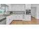 Well-lit kitchen features white cabinetry, granite countertops, and modern appliances at 2702 Moorings Pkwy, Snellville, GA 30039