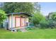 Backyard shed with double doors and a small covered porch, providing extra storage space at 2702 Moorings Pkwy, Snellville, GA 30039