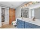 Bright bathroom with double sinks, a blue vanity, an enclosed toilet, and a large walk-in closet at 329 Kyles Cir, Hiram, GA 30141