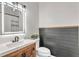 Modern bathroom featuring a wood vanity, updated mirror and lighting fixtures, and wood paneled accent wall at 329 Kyles Cir, Hiram, GA 30141