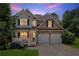 Exterior of a home with a front porch, two-car garage, and lush landscaping at 329 Kyles Cir, Hiram, GA 30141