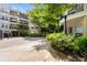 Beautiful courtyard with seating outside of a multi-unit condo building with tan siding and black metal balconies at 1850 Cotillion Dr # 4419, Atlanta, GA 30338