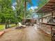 Features a covered patio with an outdoor kitchen, a seating area, and a lush green backdrop at 2956 Springlake Dr, Buford, GA 30519
