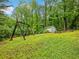 A lush backyard featuring a swing set, storage shed, picnic table and a slide surrounded by greenery at 2956 Springlake Dr, Buford, GA 30519