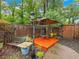 Backyard patio has a charming seating area with shade umbrella, bench, and garden details at 2956 Springlake Dr, Buford, GA 30519