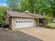Side view of the house with a two-car garage and a cozy porch swing, perfect for relaxing at 2956 Springlake Dr, Buford, GA 30519