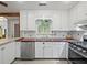Bright kitchen featuring white cabinets, stainless steel appliances, and ample counter space at 2956 Springlake Dr, Buford, GA 30519